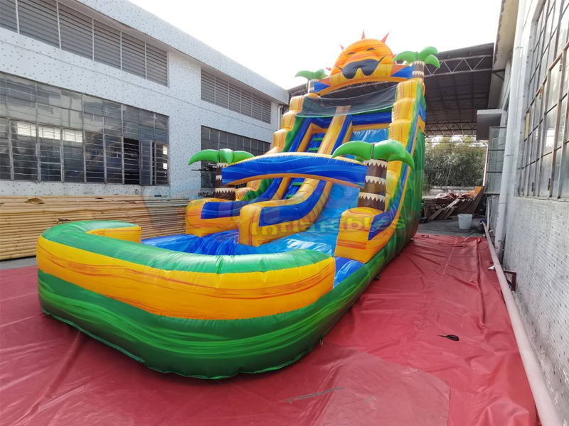 I saltatori per feste per bambini nel cortile commerciale rimbalzano sullo scivolo d'acqua gonfiabi